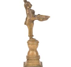 Brass Lady Holding A Diya In Her Hand And Is On A Raised Platform