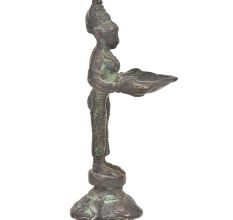 Bronze Lady Holding A Diya In Her Hand Is On A Raised Platform With Patina